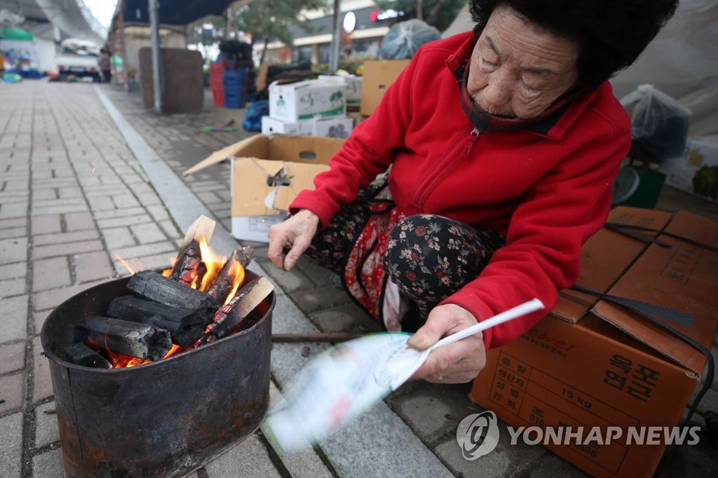 꽃샘추위에 모닥불 피우는 시장 상인